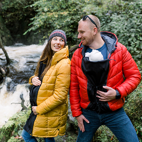Alternity Heritage jacket expander panel worn by an expectant mother, with a partner babywearing